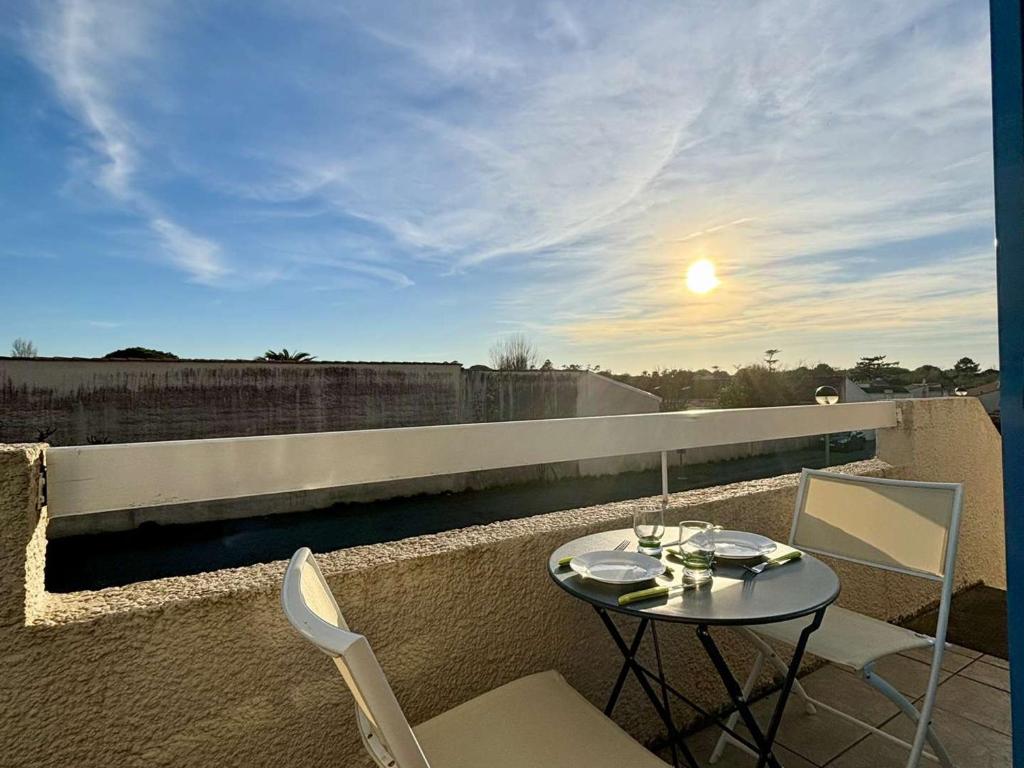 une table et des chaises sur un balcon avec vue dans l'établissement Appartement 2 pièces avec mezzanine, proche plages, piste cyclable et parking – Dolus d'Oléron - FR-1-246A-289, à Dolus-d'Oléron