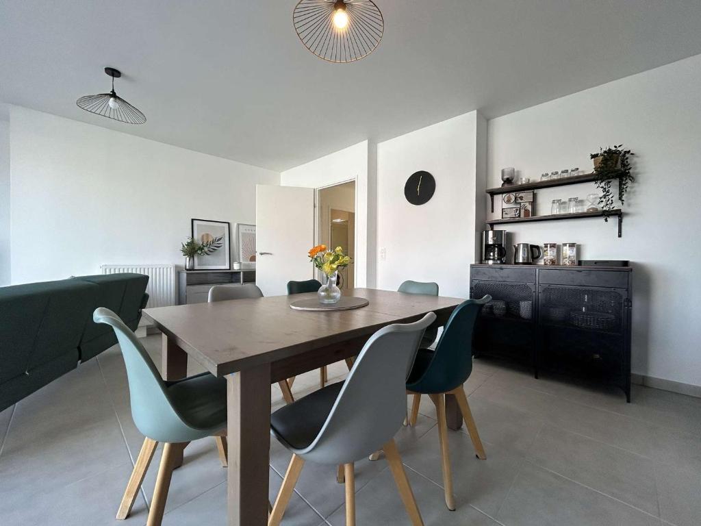 Appartement La Rochelle, 4 pièces, 8 personnes - FR-1-246-698 في لا روشيل: غرفة طعام مع طاولة خشبية وكراسي زرقاء