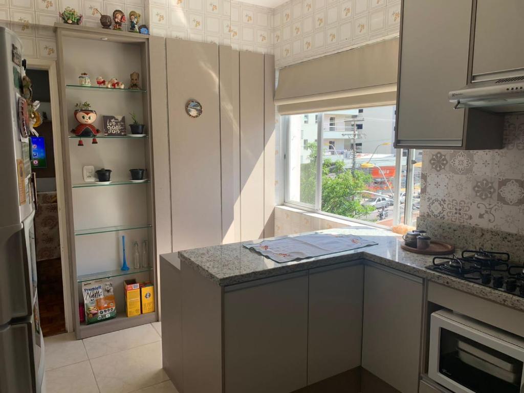 uma cozinha com um balcão e uma janela em Apto central completo com garagem em Caxias do Sul