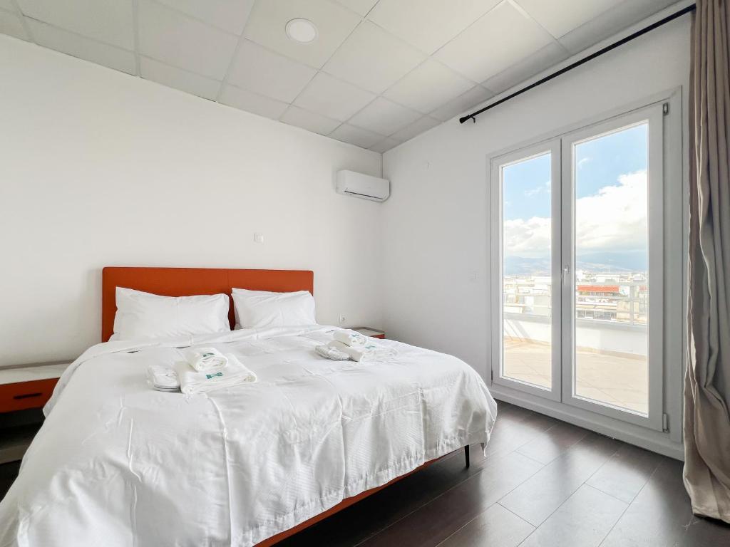 a bedroom with a white bed with a large window at ANhome K11 serviced apartments Plus in Athens