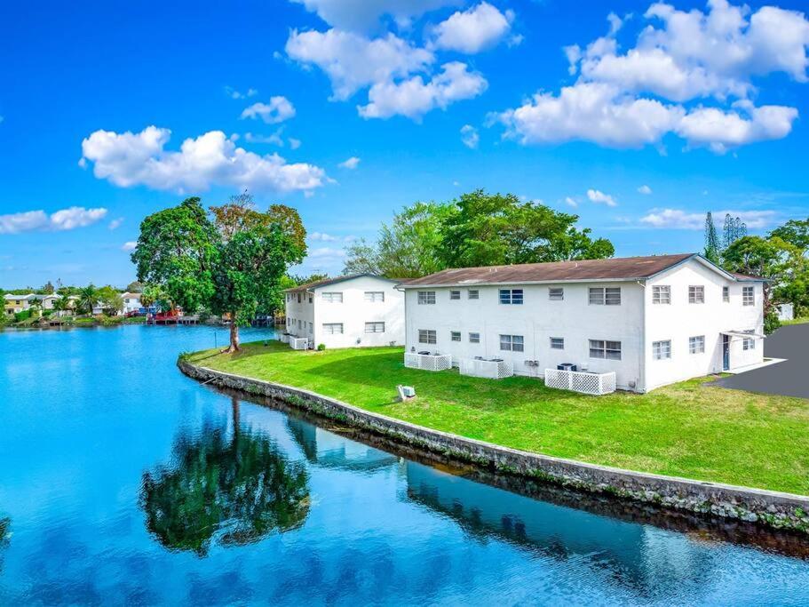a house next to a river with blue water at Stylish - Water View Condo - Palm Wave Says in Coconut Creek