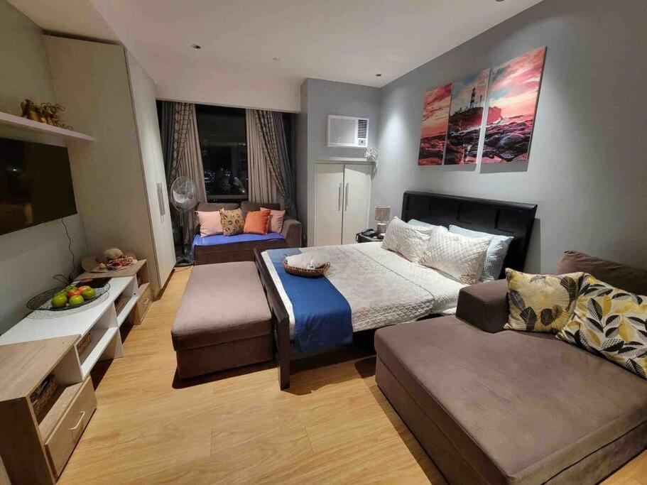 um quarto grande com uma cama e um sofá em Bright Comfy Room w/WiFi near Makati/Manila/Philippines em Manila