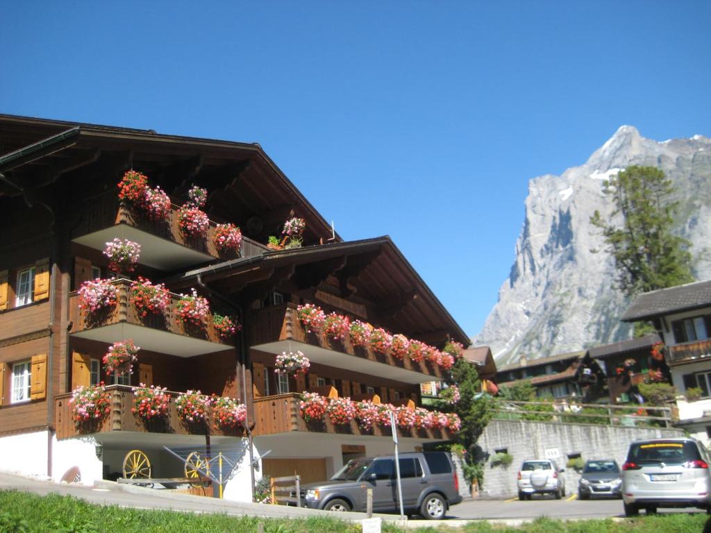 グリンデルワルトにあるホテル アルテ ポストの花の横の建物