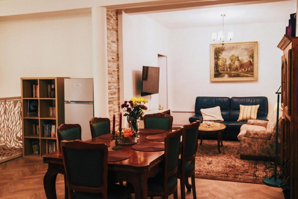 ein Wohnzimmer mit einem Tisch und einem Sofa in der Unterkunft La Chouette - Appartement 70m2 PMR in Château-Thierry