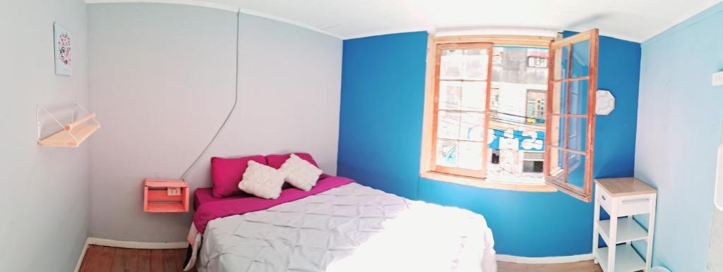 een slaapkamer met blauwe en witte muren en een bed bij Valpro Hostal in Valparaíso