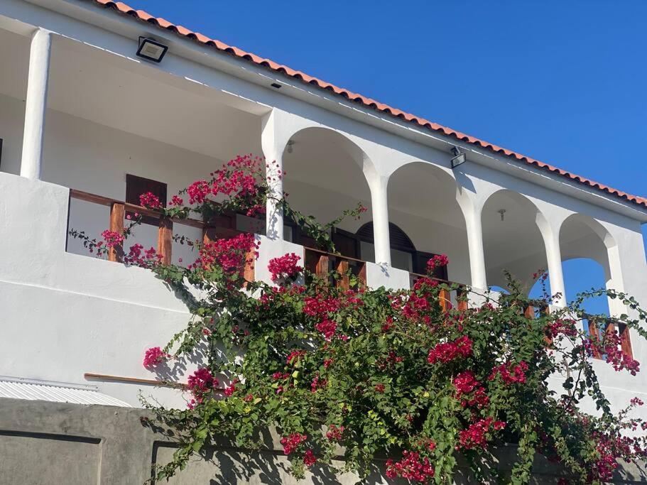 un edificio blanco con flores en el balcón en Casa Zanelli, lugar de paz… en Baní