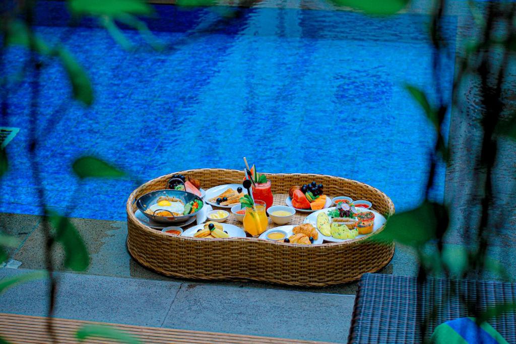 a basket of food on a table next to a pool at Swiss-Belexpress Kuta Legian in Kuta