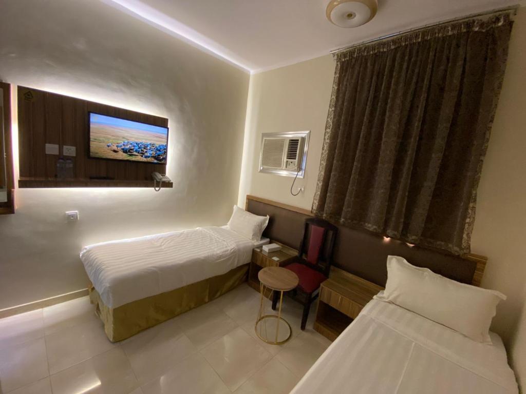 メディナにあるفندق المأمون - ALMAMOUN HOTELのベッド2台とテレビがあるホテルの部屋
