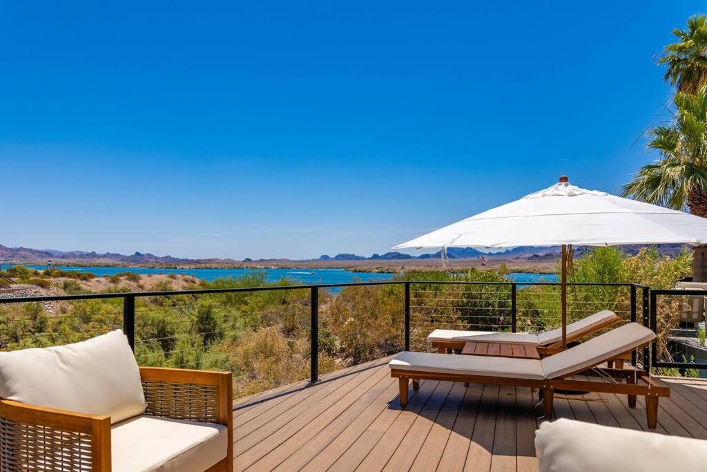 eine Terrasse mit einem Tisch, Stühlen und einem Sonnenschirm in der Unterkunft Lakeside Luxury - Sams Beachcomber Lake Access in Lake Havasu City