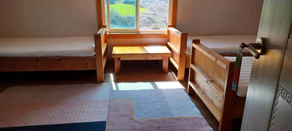濟州的住宿－나무집 게스트하우스，客房设有两张床和窗户。