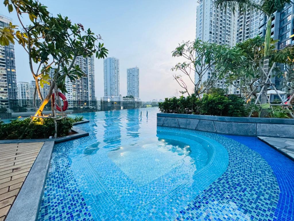 ein Schwimmbad in der Mitte einer Stadt mit hohen Gebäuden in der Unterkunft THE LUMIÈRE RIVERSIDE LUXURY SUITE in Ho-Chi-Minh-Stadt