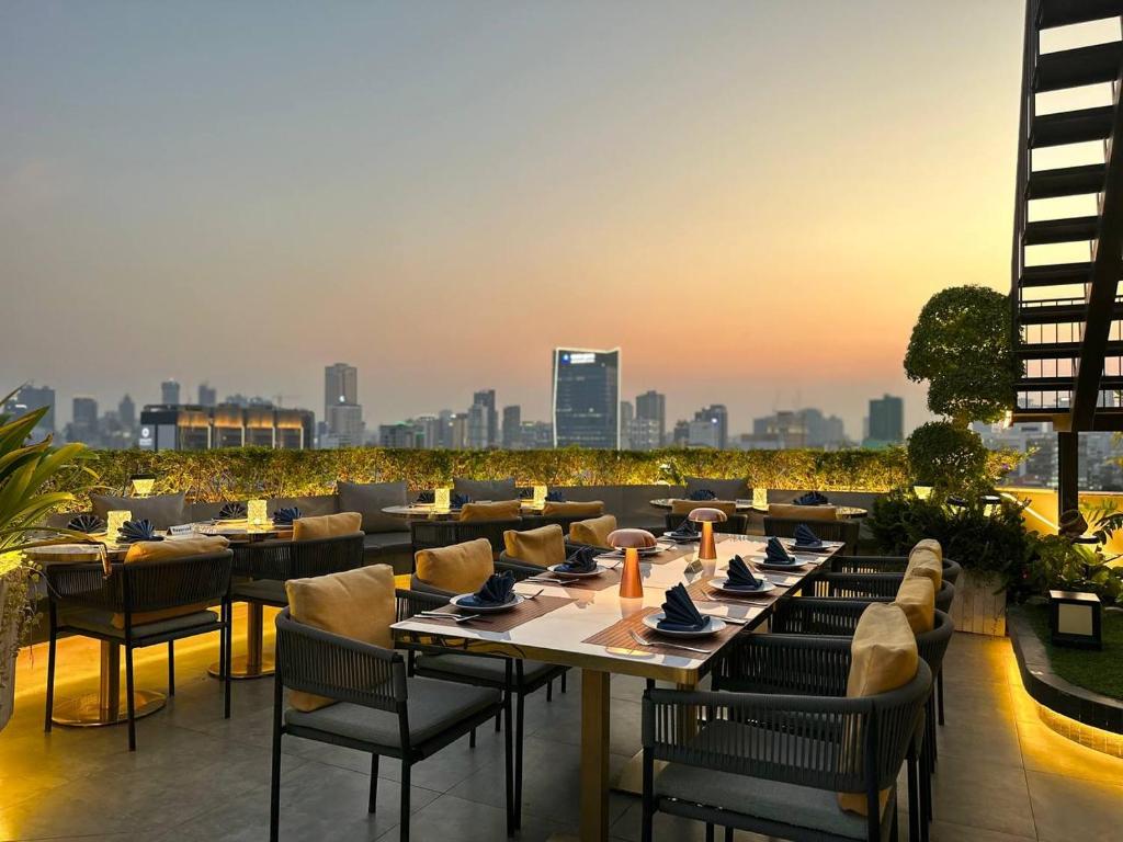 a restaurant with tables and chairs and a city skyline at Harmony Phnom Penh Hotel in Phnom Penh