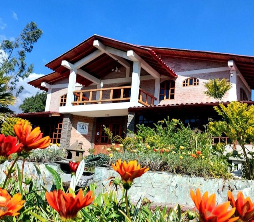 een huis met bloemen ervoor bij Quinta Sierra de Fuego in Penipe