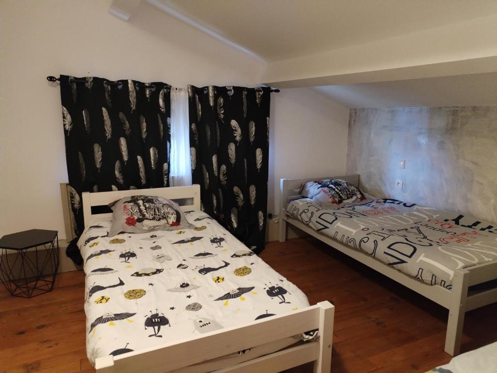 1 Schlafzimmer mit 2 Betten in einem Zimmer in der Unterkunft Chambre 3 lits simples cuisine commune in Saint-Pierre-du-Mont