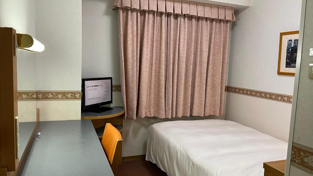 御殿場市にあるホテルアルファーワン御殿場インターのベッドと机とパソコンのある部屋