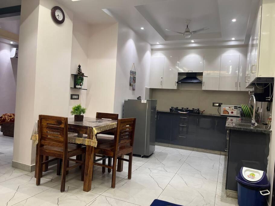 a kitchen with a table and chairs and a refrigerator at Luxury Home 2BHK 3AC Terrace View Lift Kitchen in Hills Tapovan in Rishīkesh