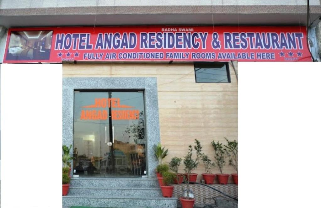 un bâtiment avec un panneau rouge à l'avant dans l'établissement ANGAD RESIDENCY, à Amritsar