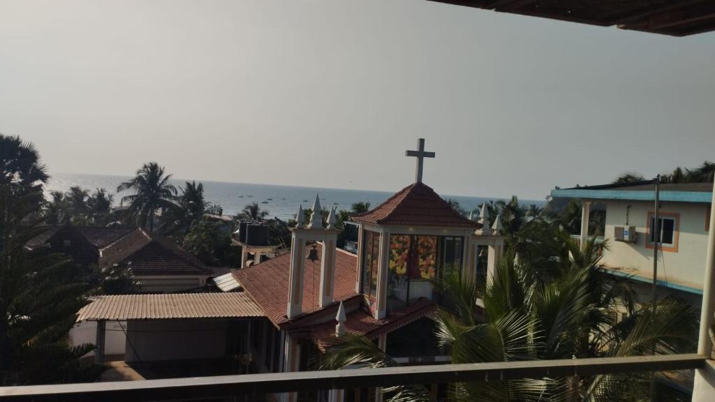 a church with a cross on top of a building at Beach Doorz Place-TBV in Baga