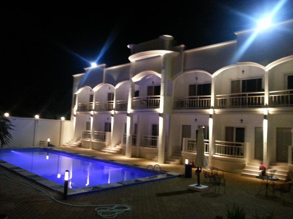 un gran edificio blanco con piscina por la noche en shillahotel and resort en Ángeles