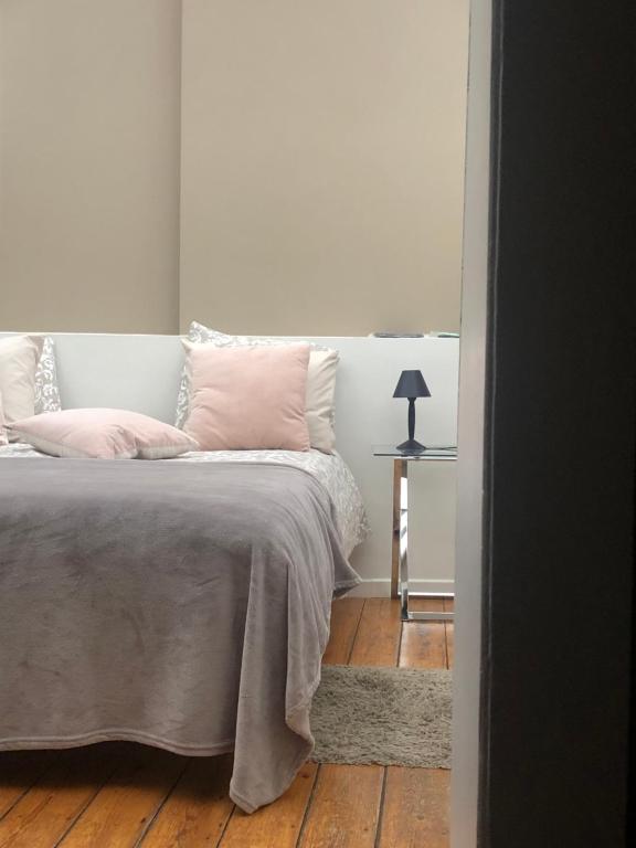 um quarto com uma cama com almofadas cor-de-rosa e uma mesa em Tongeren Schuttersgang 1 em Tongeren