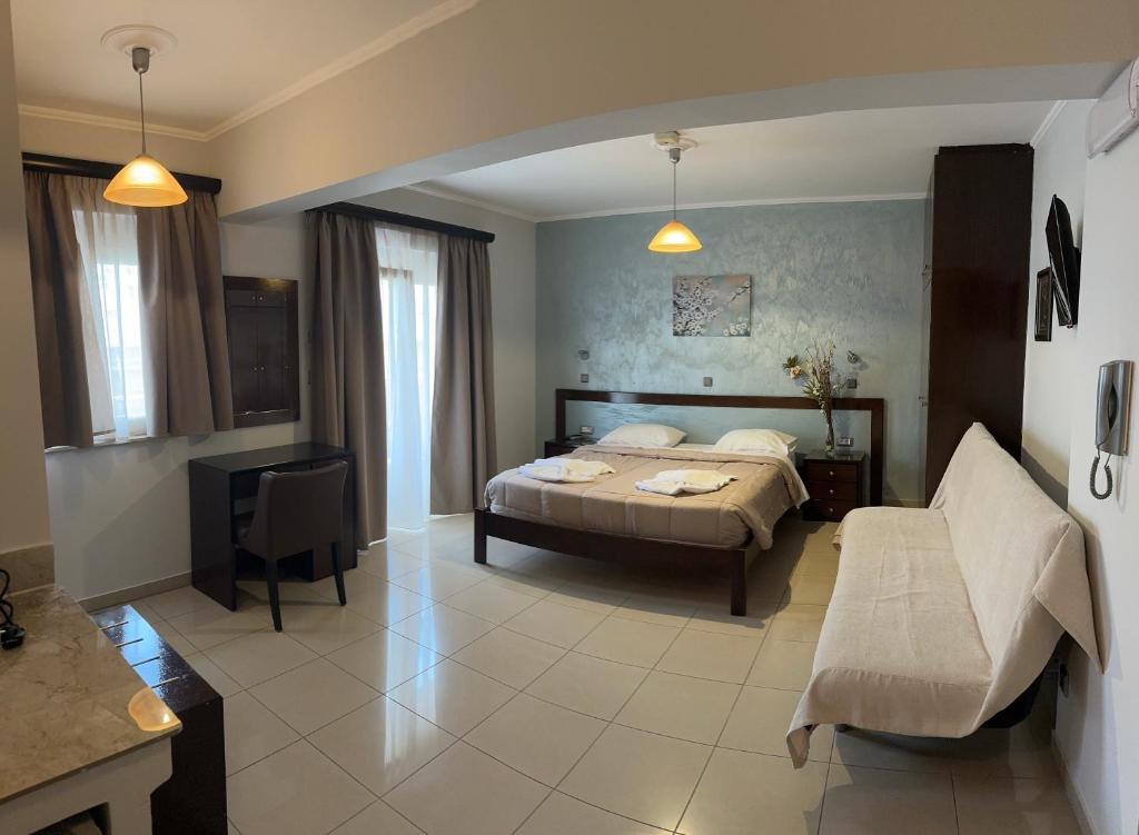 a bedroom with a bed and a table and a couch at Comfort Hotel Apartments in Rhodes Town