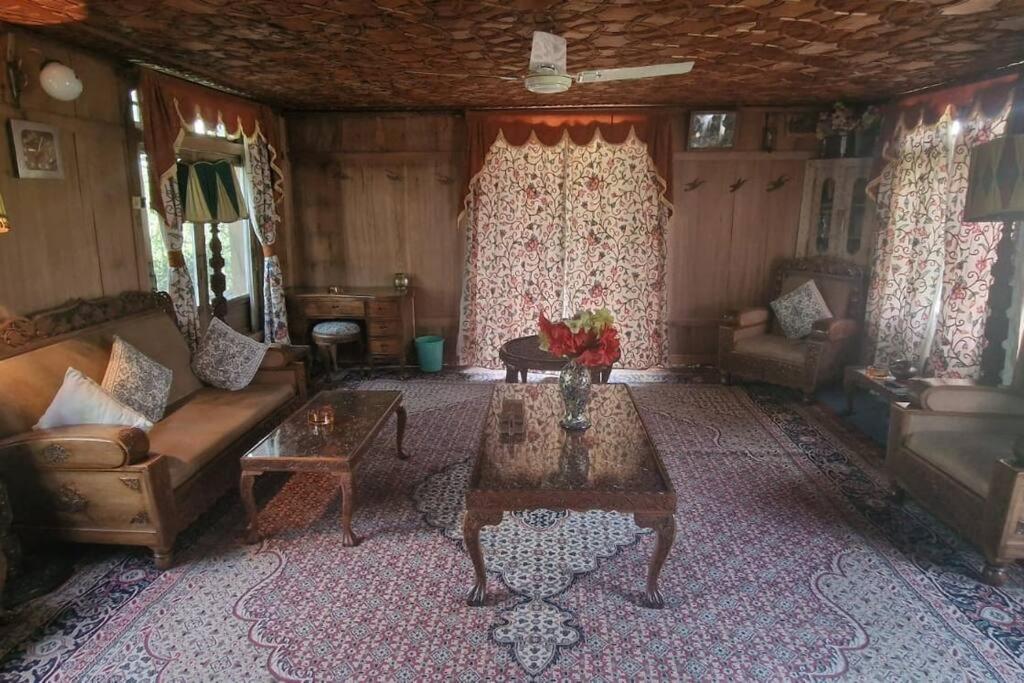 sala de estar con sofá y mesa en Queens Lakehouse en Srinagar