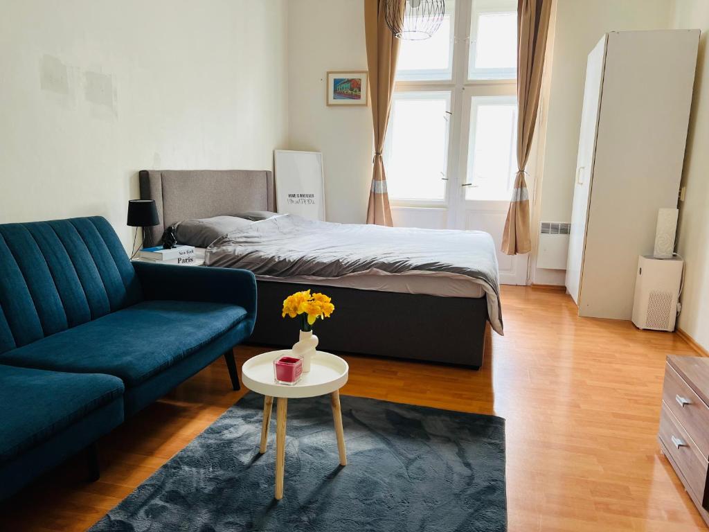 a living room with a bed and a couch and a table at Muchovka Apartment in Prague