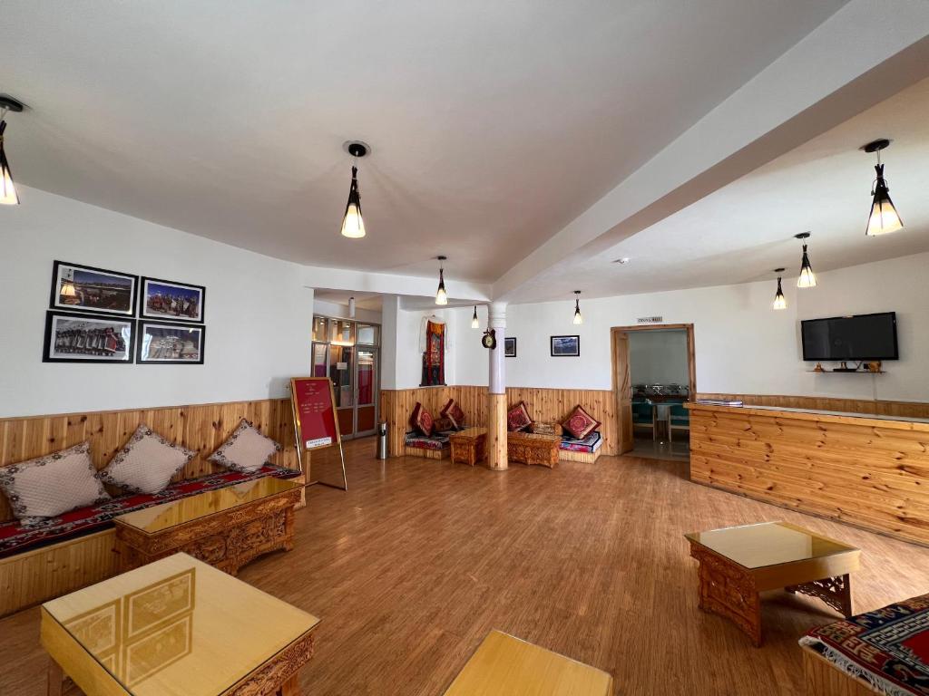 ein großes Wohnzimmer mit Sofas und einem Flachbild-TV in der Unterkunft Hotel New Glacier View in Leh