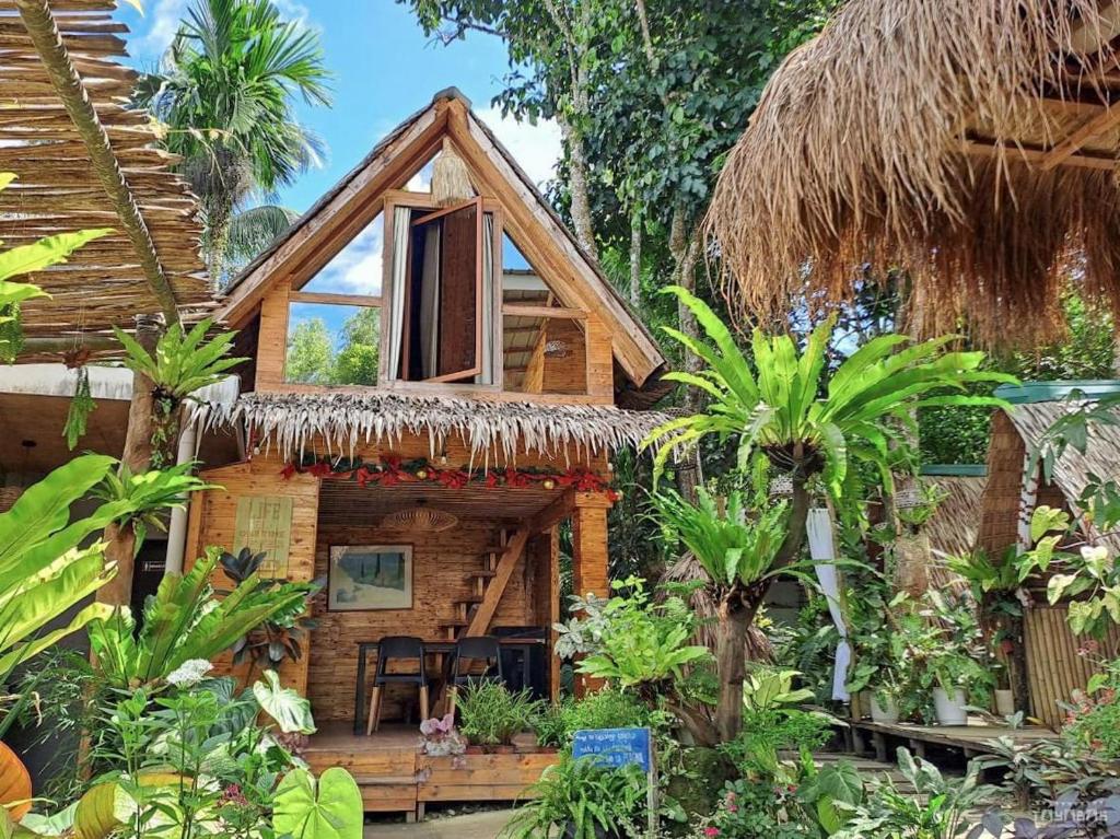 Tayabas的住宿－Juans Cabin，一间有稻草屋顶的小房子