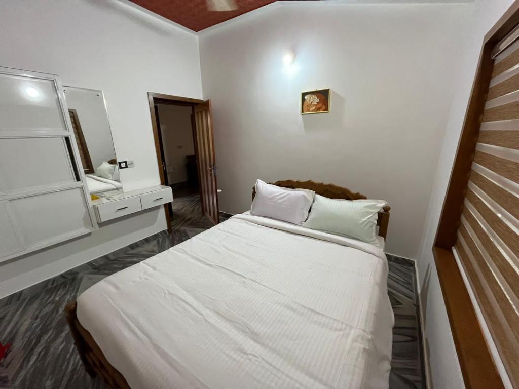 ein kleines Schlafzimmer mit einem Bett und einem Spiegel in der Unterkunft Souparnika Homestay in Kannur