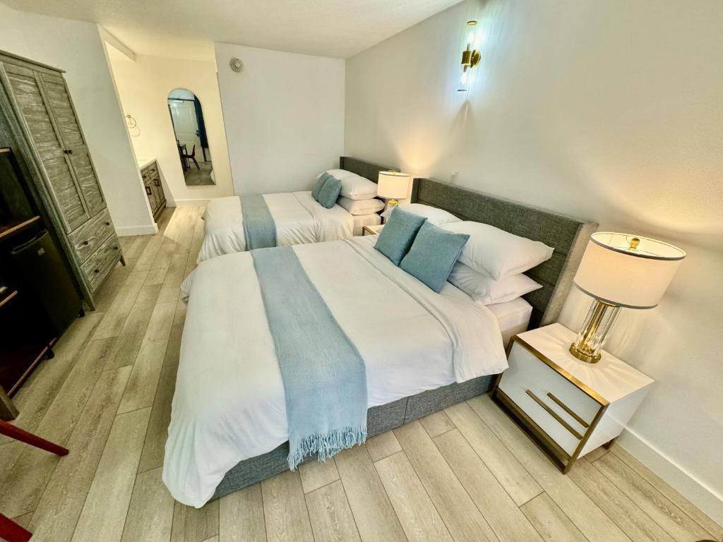 um quarto com 2 camas com almofadas brancas e azuis em Pool - WiFi - Gym - Parking - Best Location ! em Kissimmee