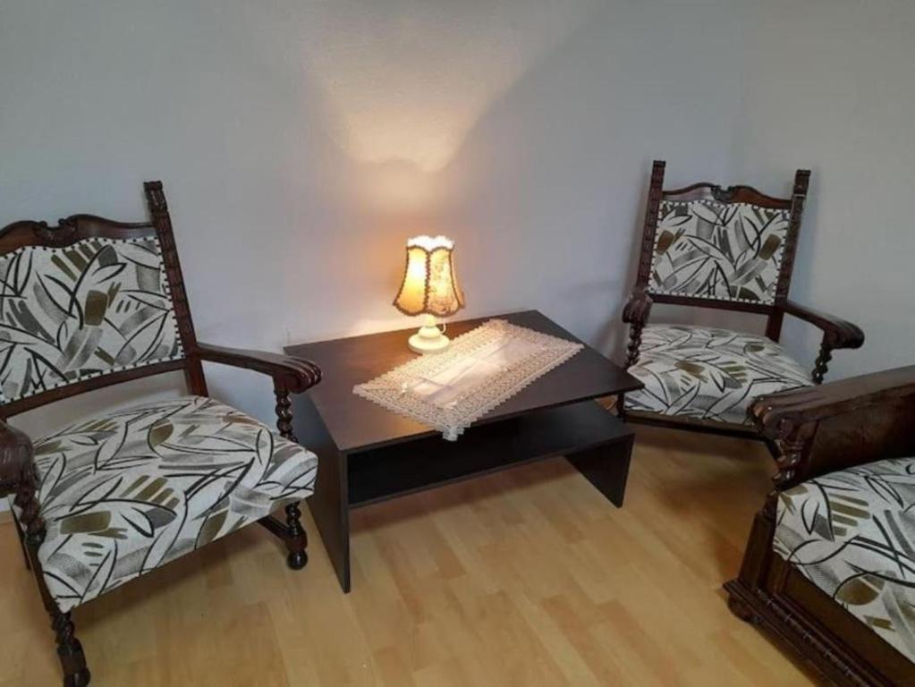 um quarto com duas cadeiras e uma mesa com um candeeiro em LBB apartman em Sátoraljaújhely
