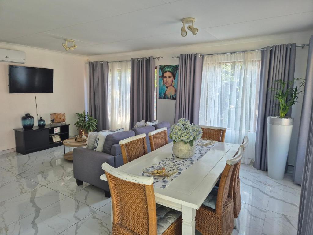 a living room with a table and a couch at A&F Cottage with pool n braai in Sandton