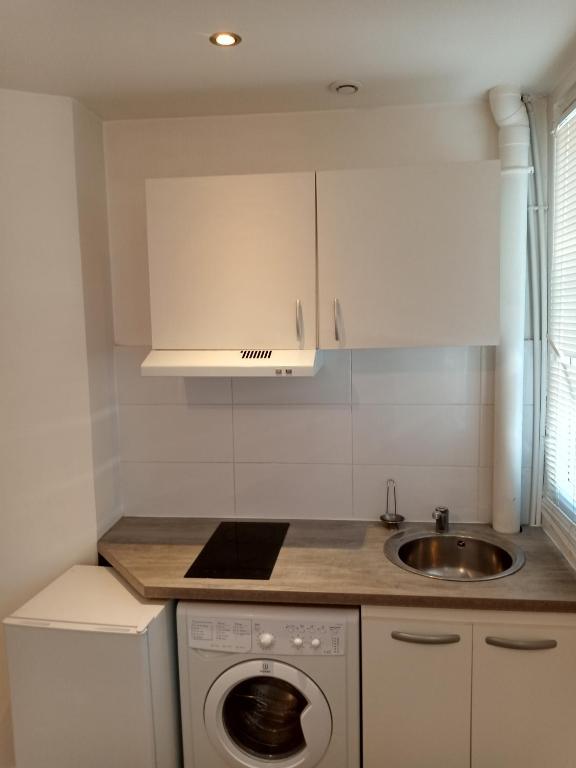 a kitchen with a washing machine and a sink at Joli in Clichy