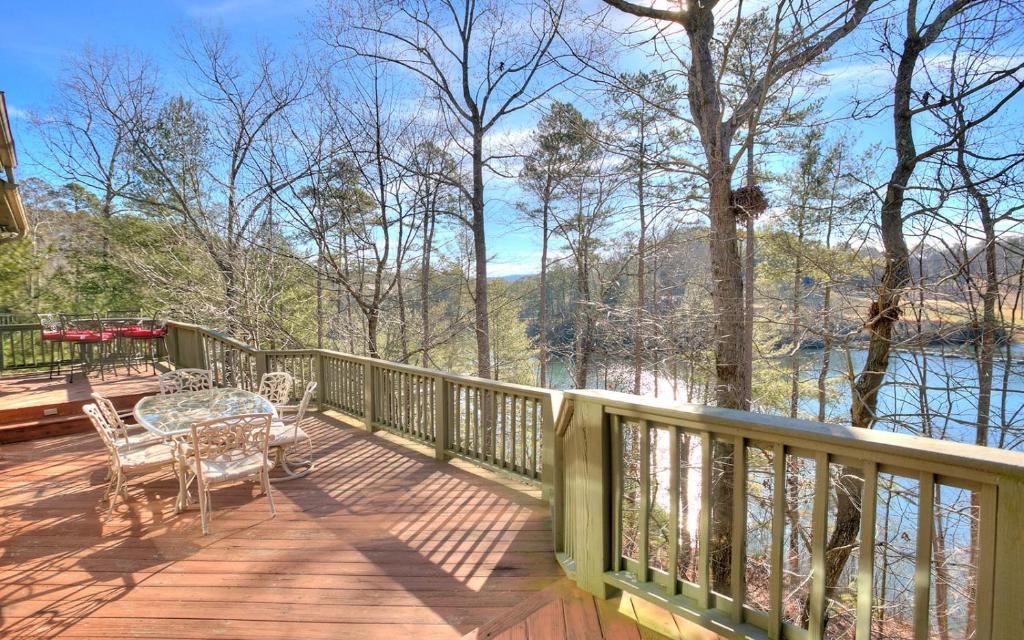 a wooden deck with a table and chairs on it at Paradise Retreat - Luxury chalet on Lake Disharoon with foosball in Marblehill