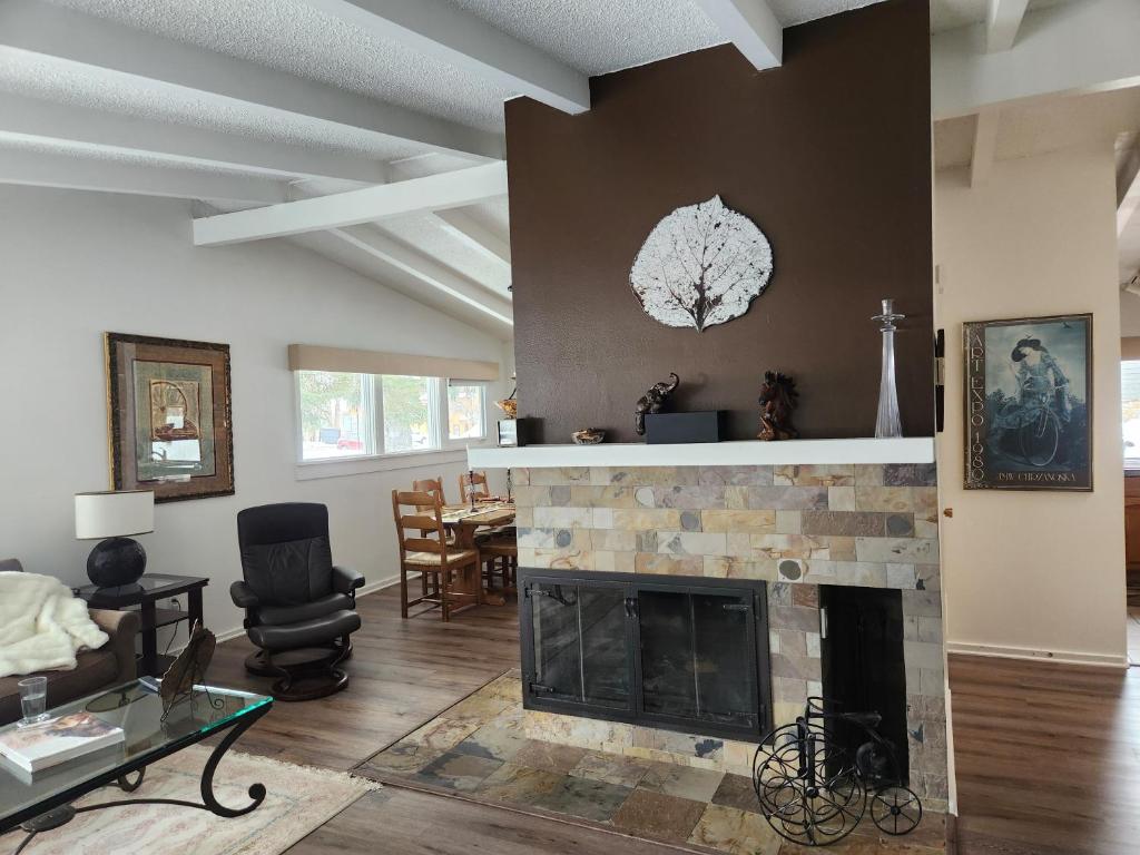 a living room with a fireplace and a table at Aspen West End Home in Aspen