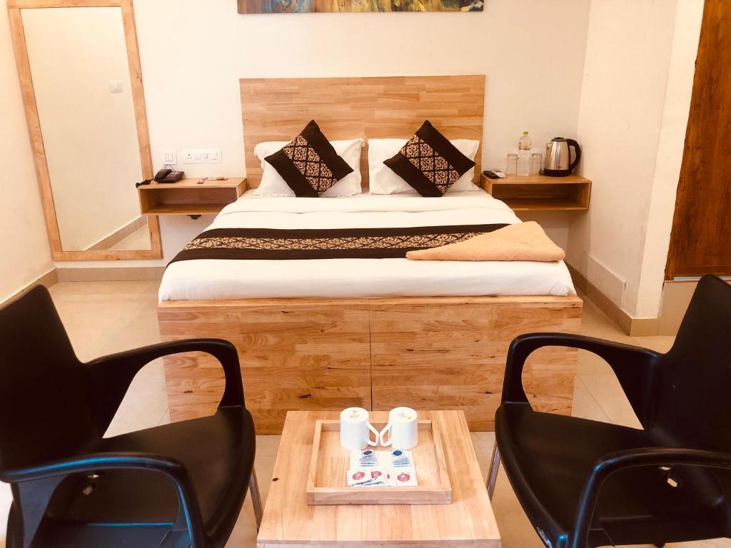 um quarto com uma cama, 2 cadeiras e uma mesa em RAINBOW ROOMS em Calecute