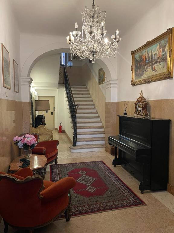 a living room with a piano and a chandelier at Miglioranzi Rooms in Verona