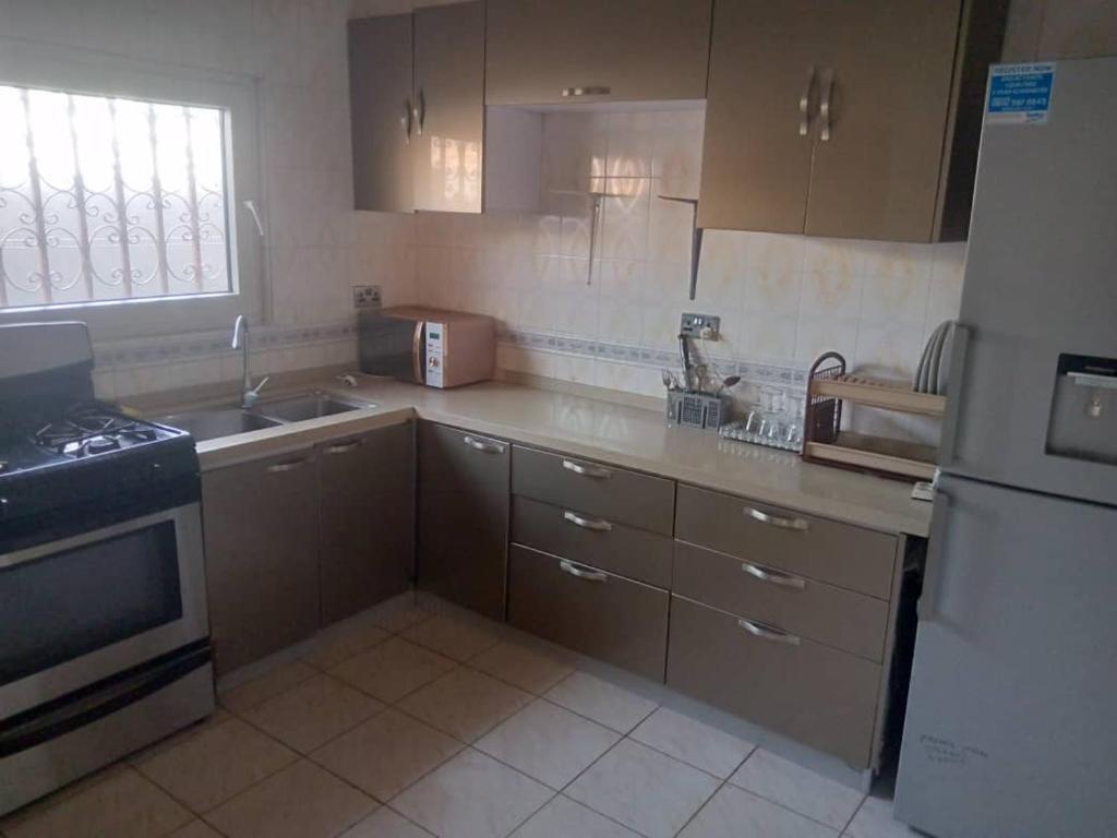 a kitchen with a sink and a stove and a refrigerator at Costal Road hideout! in Ghana Town