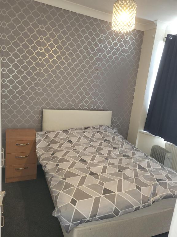 a bedroom with a bed with a hexagonal pattern on the wall at UNIVERSITY HOMES in Middlesbrough
