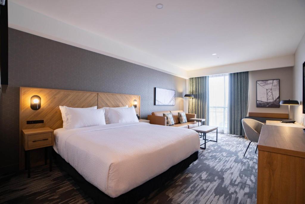 ハリファックスにあるSandman Signature Dartmouth Hotel & Suitesのベッドとリビングルームが備わるホテルルームです。