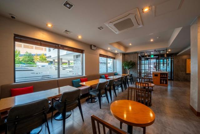 I-check Hyunjin Hotel في دونغ هاي: مطعم بطاولات وكراسي ونافذة كبيرة