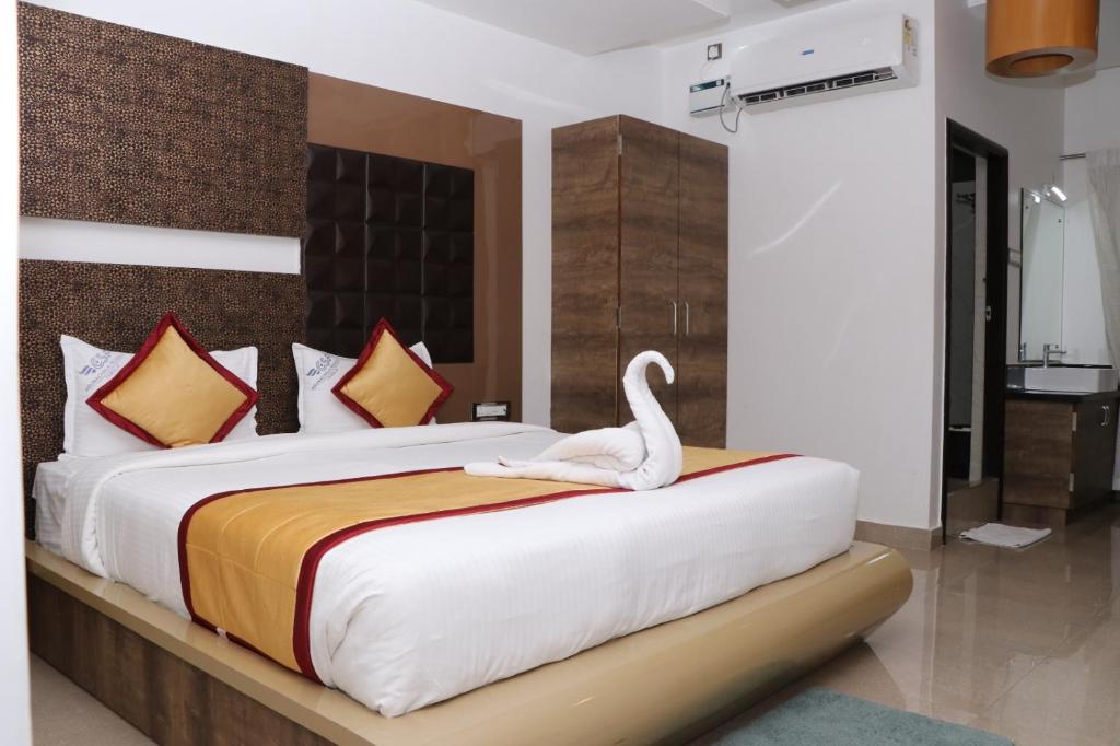 a bedroom with a bed with a swan on it at CS Arunachala Residency in Tiruvannāmalai