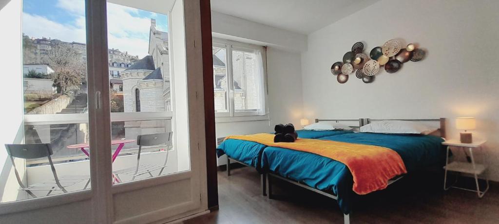 une chambre avec un lit sur lequel est assis un chat dans l'établissement Studio Château Durieux 2 centre-ville proche thermes idéal vacances et cure thermale, à Aix-les-Bains