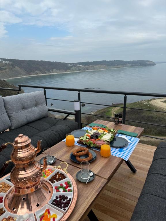 a table with food on a balcony with a view of the ocean at Marina Fener Hotel & Suite in Istanbul
