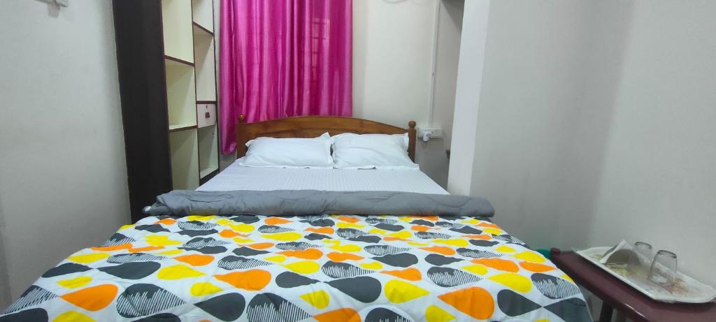 ein Schlafzimmer mit einem Bett mit einer bunten Bettdecke in der Unterkunft ANDAMAN EXQUISITE in Port Blair