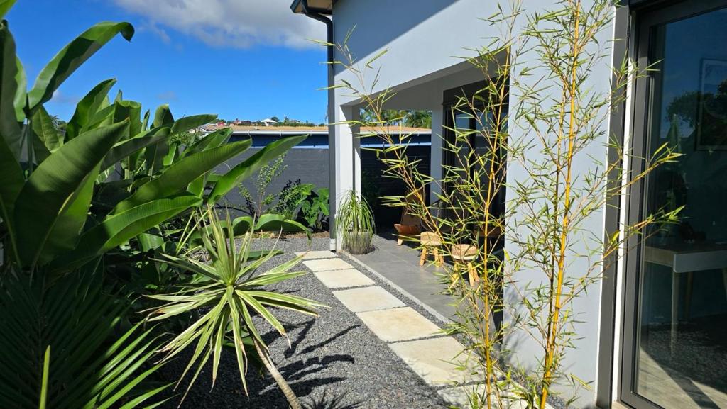 een tuin met planten aan de zijkant van een huis bij ENTRE-DEUX VACANCES in Entre-Deux