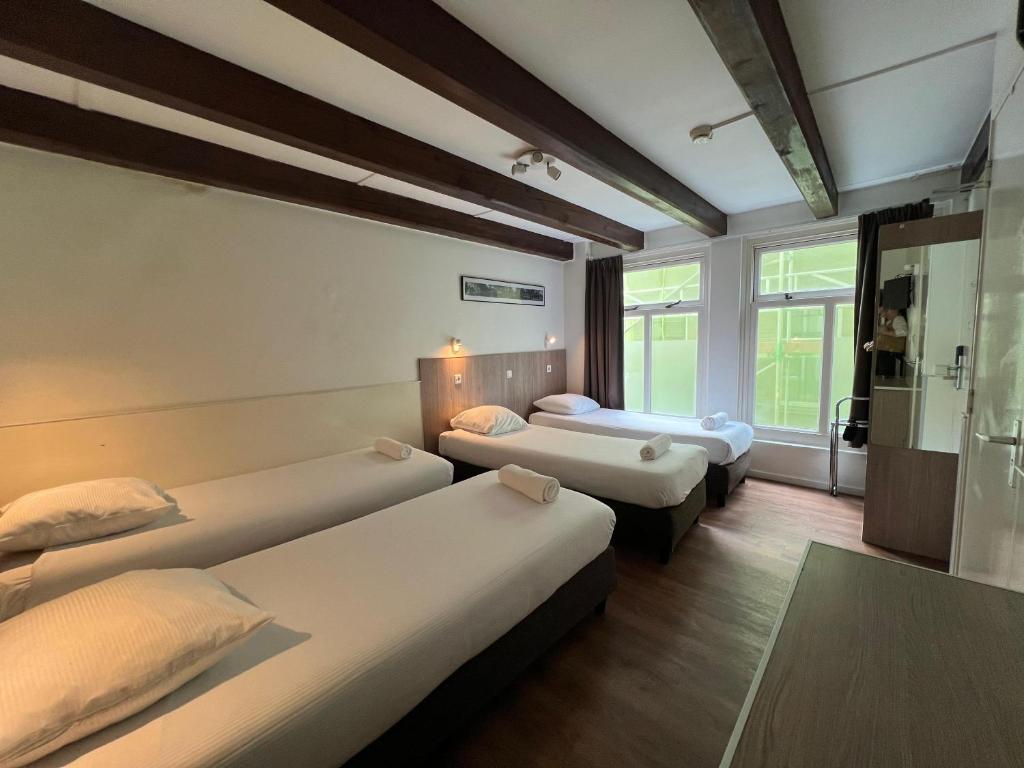 阿姆斯特丹的住宿－老城區酒店，酒店客房设有三张床和窗户。