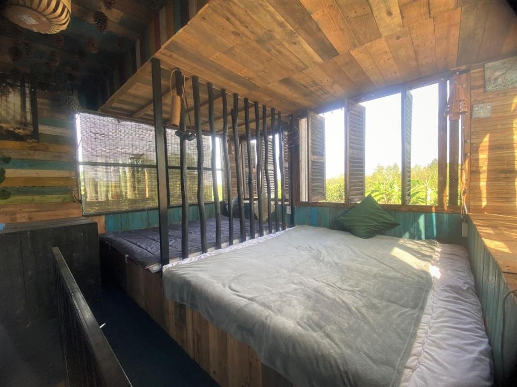 a room with a bed in a wooden cabin at Cat Canh Farm in Ho Chi Minh City