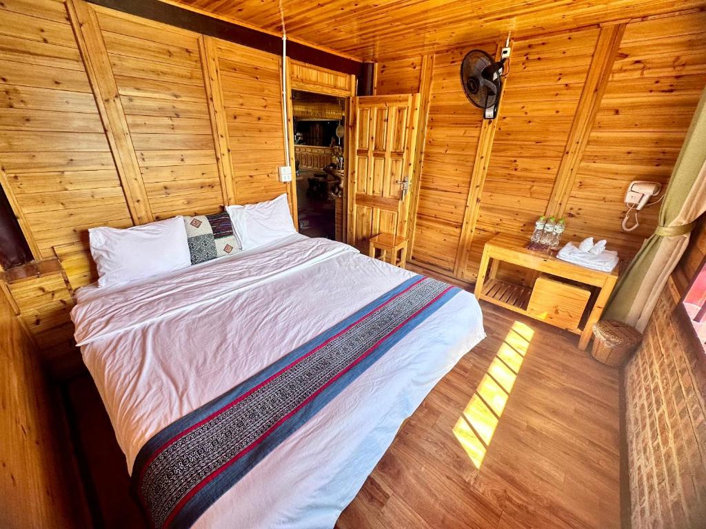 een slaapkamer met een bed in een houten kamer bij Eco Farmer House Sapa in Lao Cai